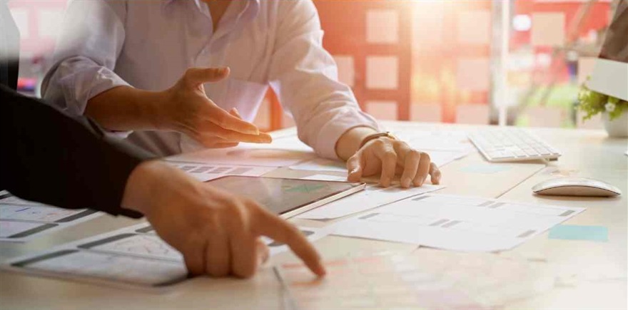Table with plans and people pointing