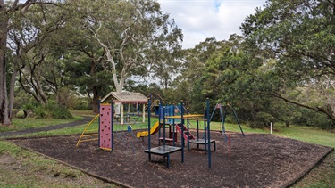 Boronia Park North Playground, featuring a number of climbing frames plus a swing-set. Shows a small gazebo in the background as well as another (smaller) playground.